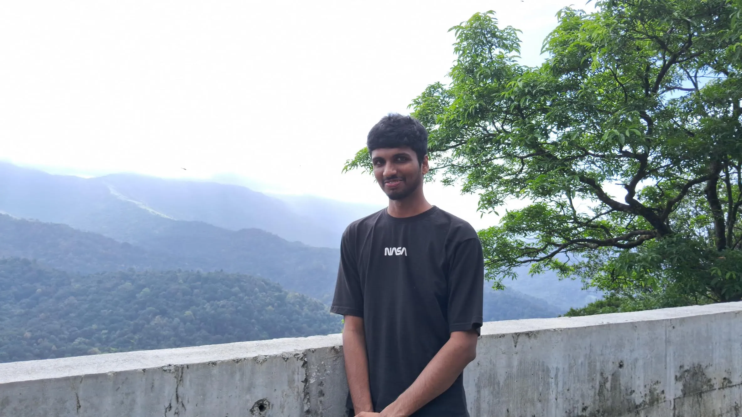 Srujan in the Western Ghats with mountains behind