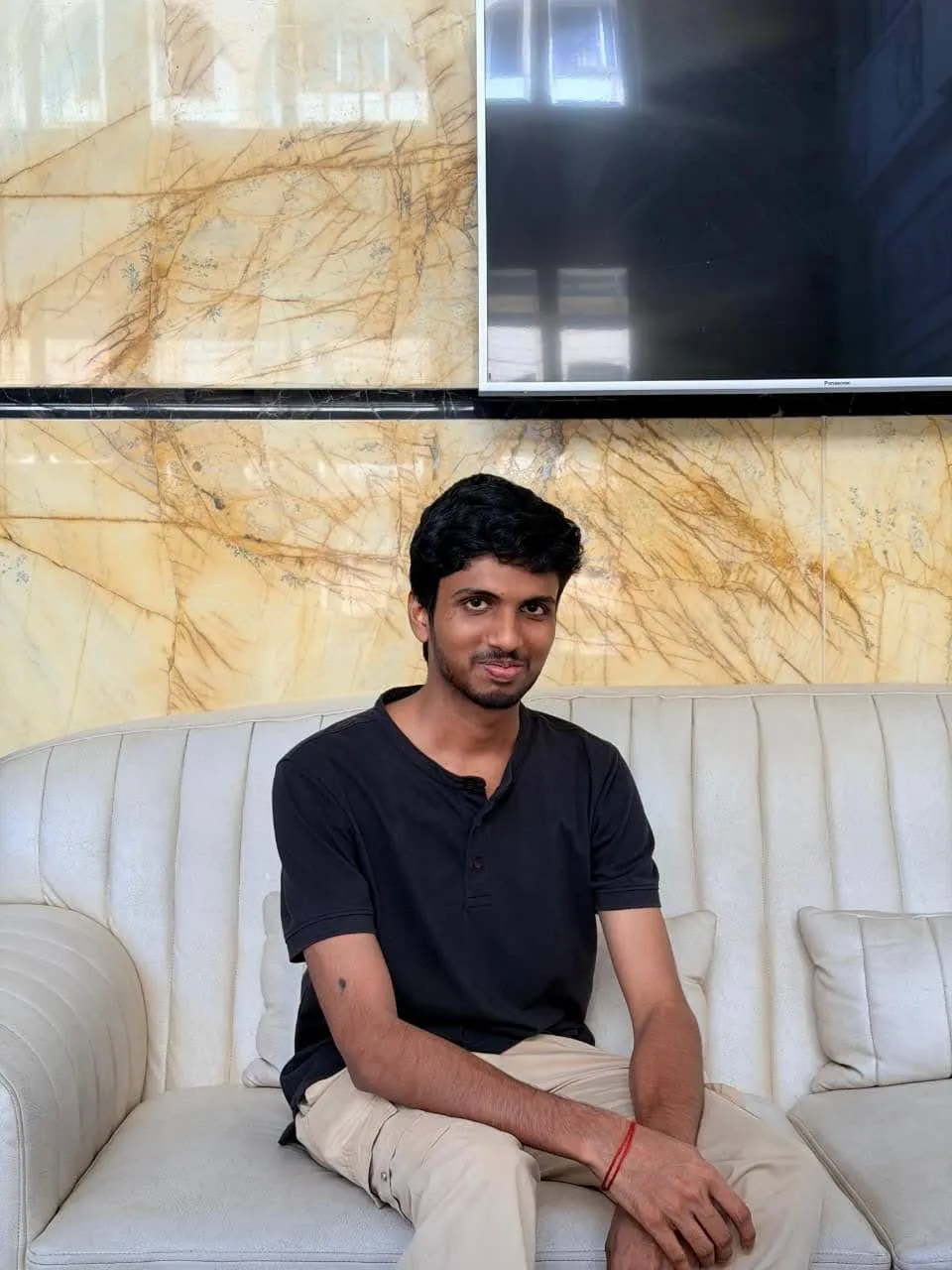 Srujan sitting on a sofa